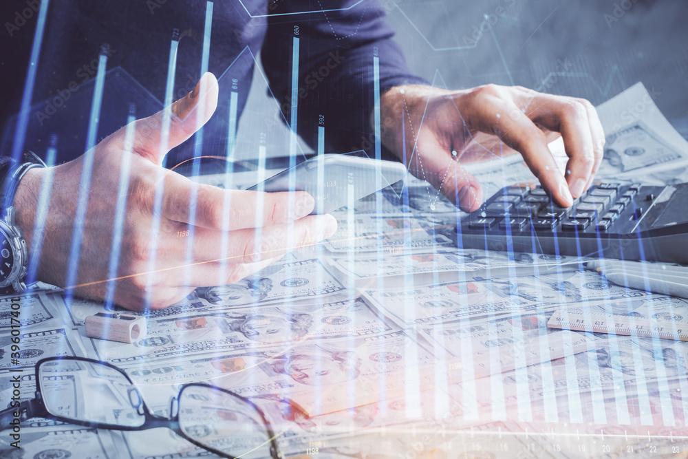 Double exposure of man's hands holding and using a digital device and forex graph drawing. Financial market concept. Double exposure of man's hands holding and using a digital device and forex graph drawing. Financial market concept.