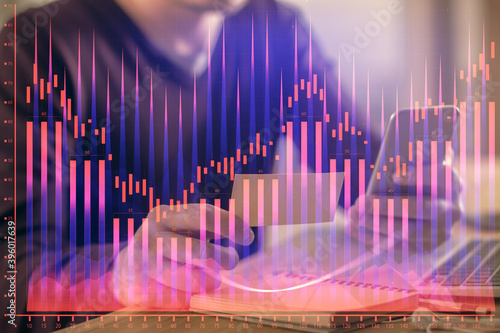 Double exposure of man's hands holding and using a phone and financial graph drawing. Analysis concept. © peshkova