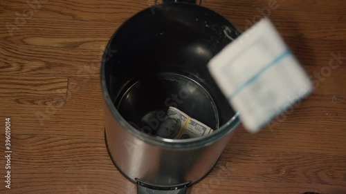 throwing away money in trash