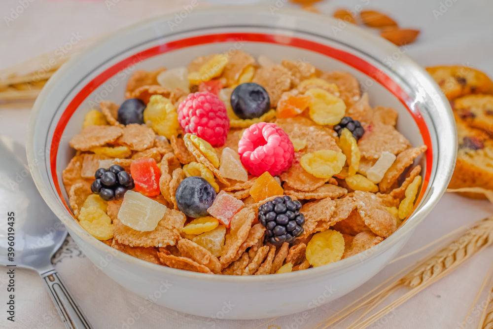 Healthy breakfast. Sunlight, dry muesli, spikelets, candied fruits and ripe summer berries. Close-up, top view. On a white background. Selective focus. Healthy breakfast. Sunlight, dry muesli, spikelets, candied fruits and ripe summer berries. Close-up, top view. On a white background. Selective focus.
