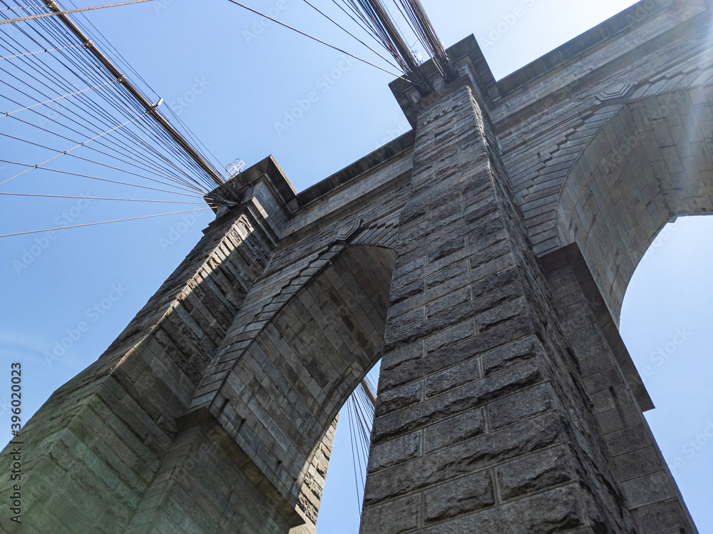 Obraz premium Looking up at arches in Brooklyn Bridge in New York on sunny summer day