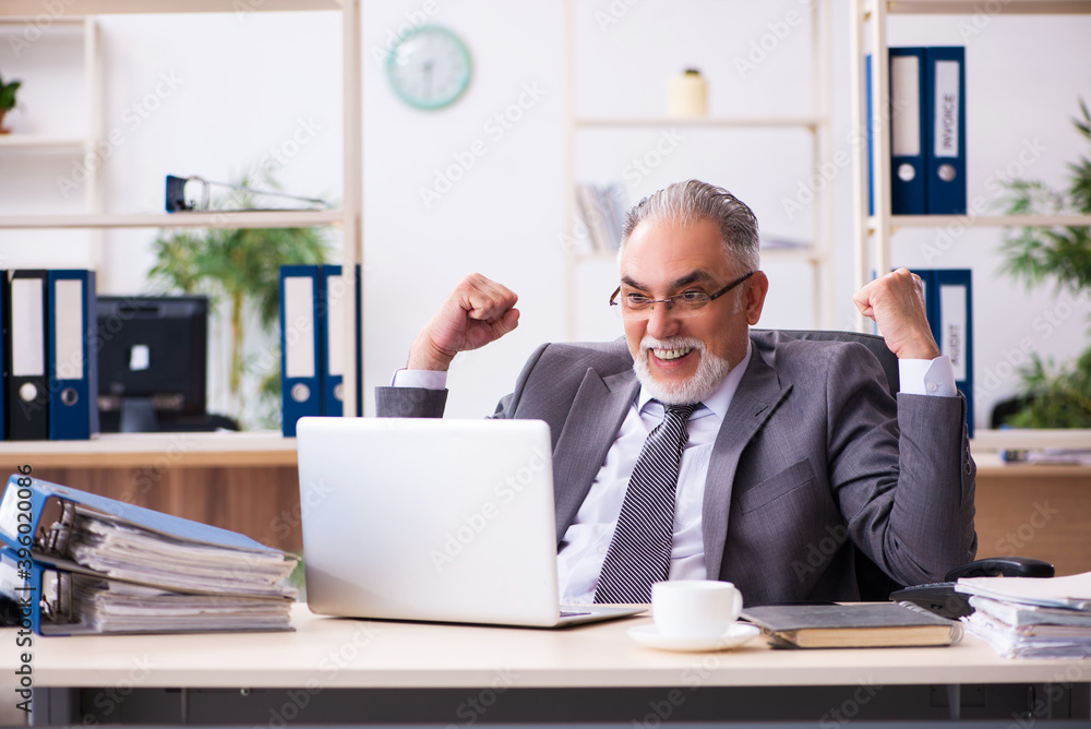 Old male employee working in the office Old male employee working in the office