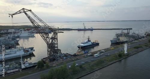 4K aerial early evening video of Lomonosov (Oranienbaum) harbour and port shipyard service area, Finnish Bay panorama, boats moored at Baltic Sea coast, in surroundings of Russia's northern capital