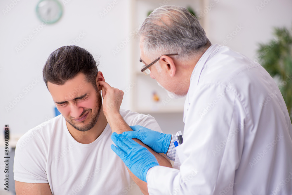 Obraz premium Young man visiting experienced doctor otolaryngologist