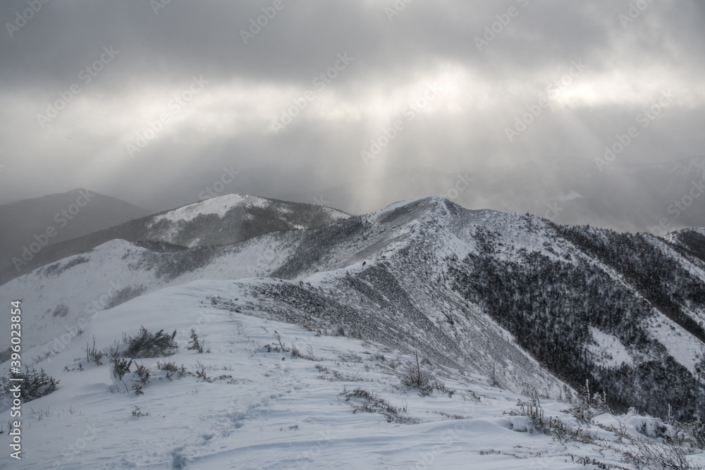 Sunbeams through the clouds over the snowy mountains range, Gaspesie, Quebec, Canada Sunbeams through the clouds over the snowy mountains range, Gaspesie, Quebec, Canada