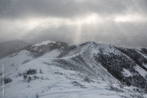 Sunbeams through the clouds over the snowy mountains range, Gaspesie, Quebec, Canada