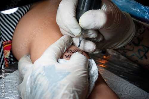 Fotografie Realizando tatuaje en brazo femenino