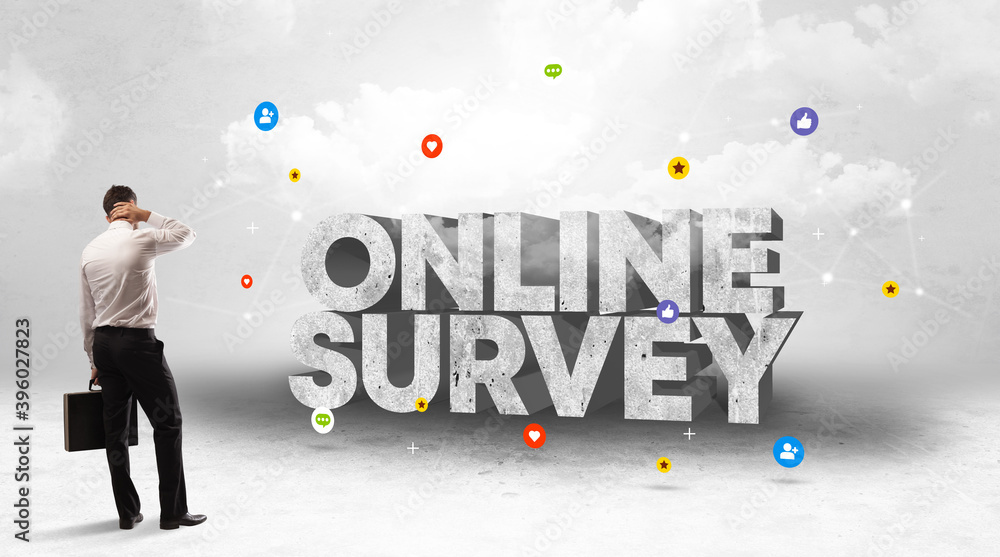 Young businessman standing in front of ONLINE SURVEY inscription, social media concept Young businessman standing in front of ONLINE SURVEY inscription, social media concept