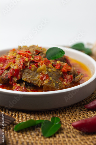 Dendeng Balado  Indonesian traditional beef cuisine from Padang  West Sumatra with slices beef cooked with some spices and a lot of chilies. served on ceramic plate and isolated white background.   