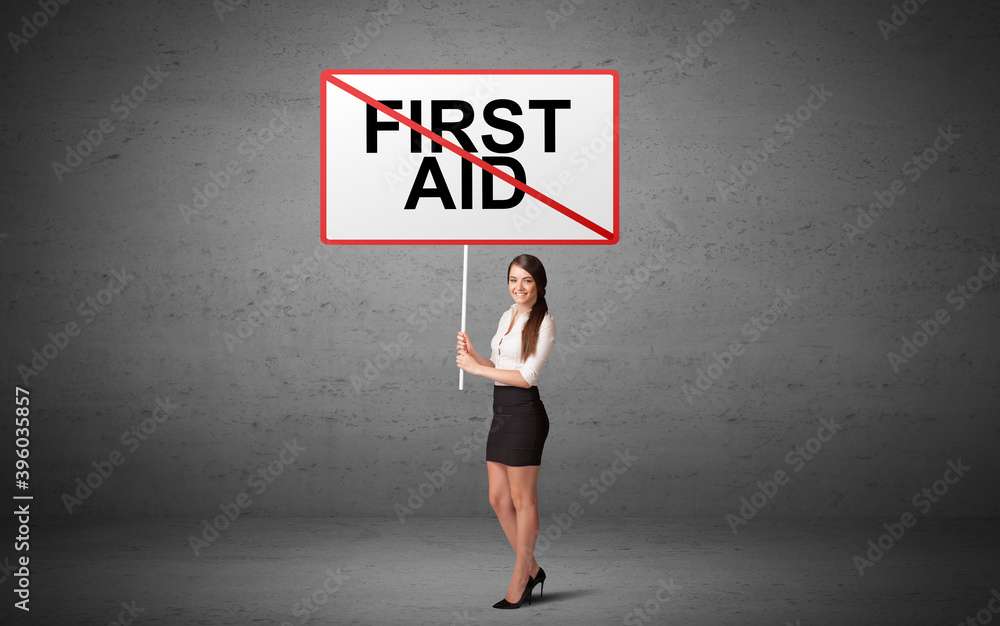business person holding a traffic sign with FIRST AID inscription, new idea concept business person holding a traffic sign with FIRST AID inscription, new idea concept