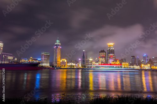 Night view of the bund at a cloudy day after raining with golden light in Shanghai, China
