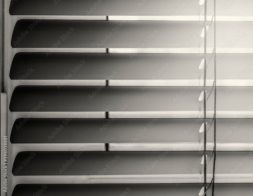 Close-up of horizontal blinds in a half-open state. In sepia tones.