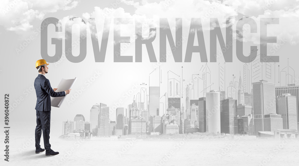 Young businessman with hard hat and GOVERNANCE inscription, new business opportunity concept Young businessman with hard hat and GOVERNANCE inscription, new business opportunity concept