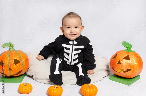 retrato de bebé pequeño con disfraz de esqueleto, sonriente, alegre. photo