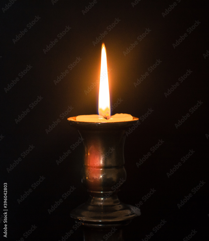 Fototapeta premium A burning candle in a candle stand