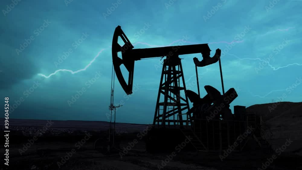 The machine for pumping oil and gas works at night during thunderstorms and lightning. Silhouette of a working oil pump from an oil field against the night sky with bright flashes of lightning. The machine for pumping oil and gas works at night during thunderstorms and lightning. Silhouette of a working oil pump from an oil field against the night sky with bright flashes of lightning.