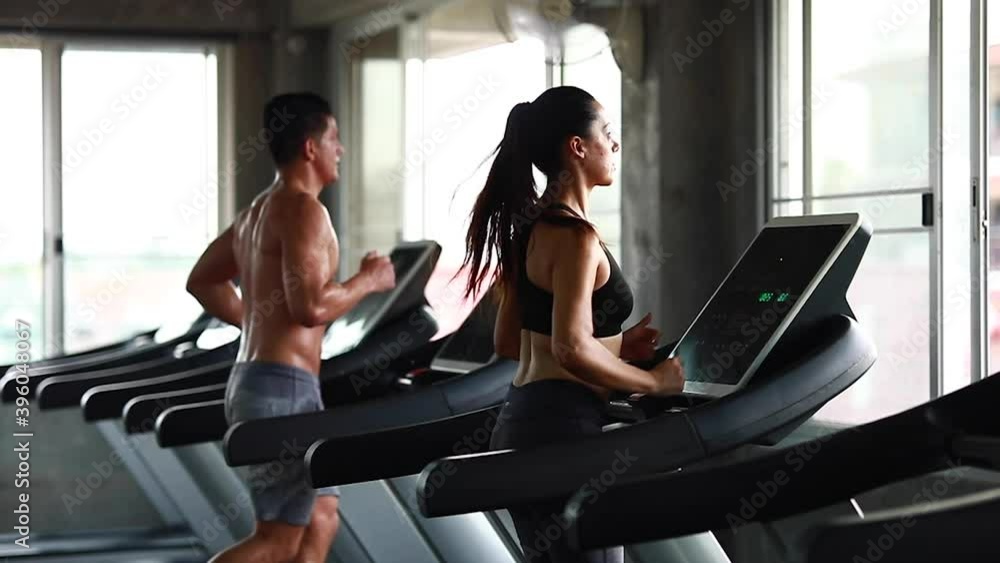 Group young peoples running on a treadmill in health club. Side view. Group young peoples running on a treadmill in health club. Side view.