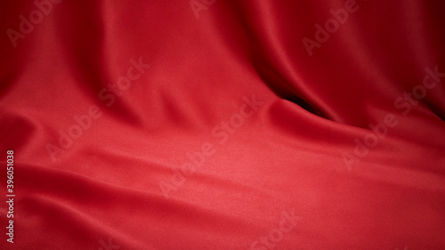 Red cloth waves texture background stage shot in table top for christmas background 