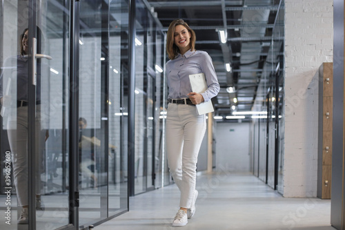 Free Download Businesswoman walking along the office corridor with documents. - GFXLoad