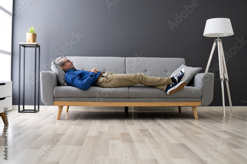 Senior Man Relaxing On Sofa