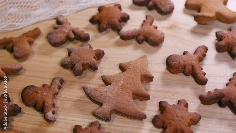 Person decorating gingerbread cookies for Christmas.