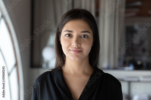 Profile picture of calm smiling indian female customer service worker assisting client online, portrait of confident mixed race woman coach tutor looking at camera providing webinar business training