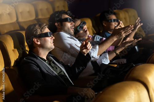 3D Movie. Group of diversity people in theater with popcorn and drinks.