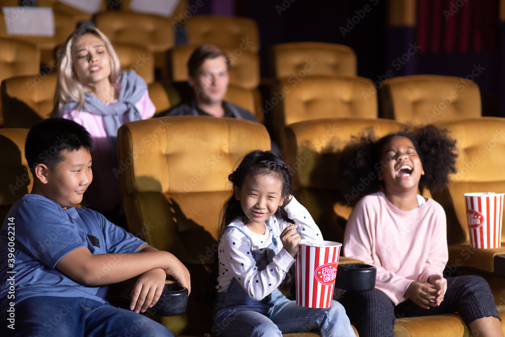 Happy family watching movie in cinema theatre. Happy family time in holiday Happy family watching movie in cinema theatre. Happy family time in holiday