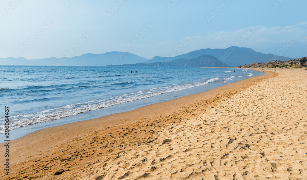 Popular resort Iztuzu beach with fine yellow sand awaits vacationers and tourists in Turkey, near Dalyan. Sea paradise and relaxation concept. This place is famous by Loggerhead turtle nesting spot Popular resort Iztuzu beach with fine yellow sand awaits vacationers and tourists in Turkey, near Dalyan. Sea paradise and relaxation concept. This place is famous by Loggerhead turtle nesting spot