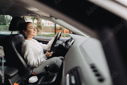Young woman driving a car in the city. © dsheremeta