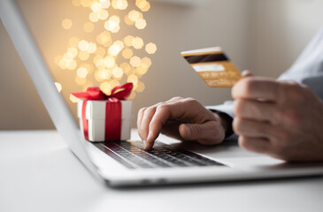 Shopping online during holidays. Man using laptop computer and credit card ordering Christmas gifts. Shopping, internet banking, store online, payment, surprise, spending money, holiday concept