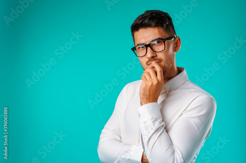 Photo of thoughtful young man touching his chin