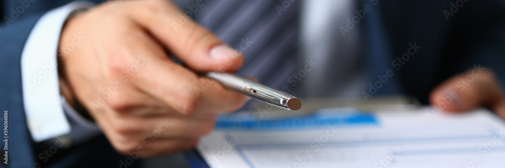 Close up of businessman that being on meeting and going to put his sign on the documents Close up of businessman that being on meeting and going to put his sign on the documents