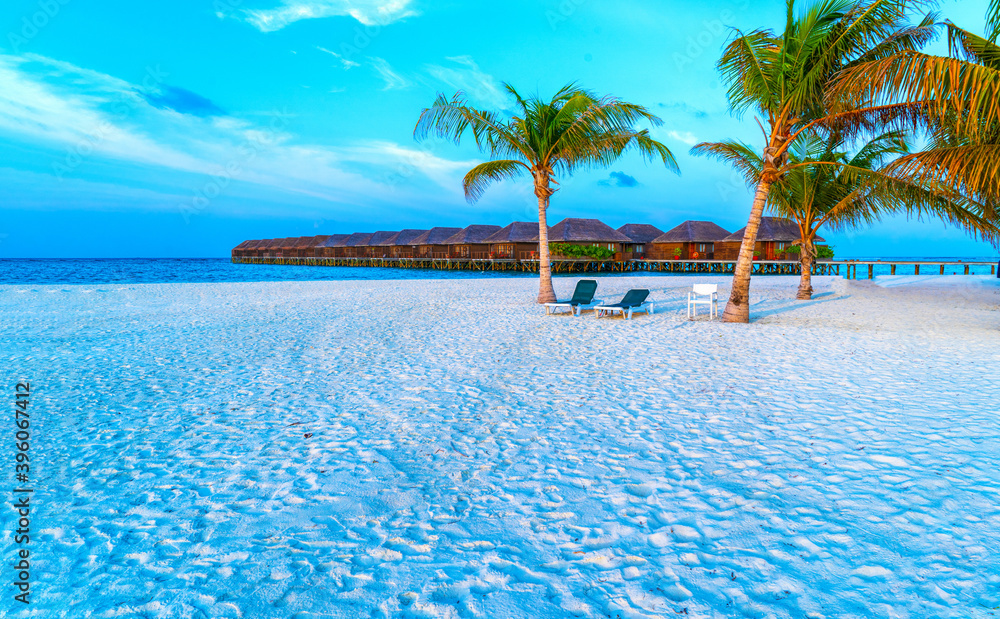 Naklejka premium Wooden bridges leading to the huts on the shores of the tropical, warm sea. Maldives. Tourism concept.