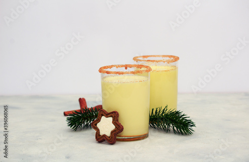 Christmas drink egnog in two glasses with chocolate chip cookies and decor on concrete background photo