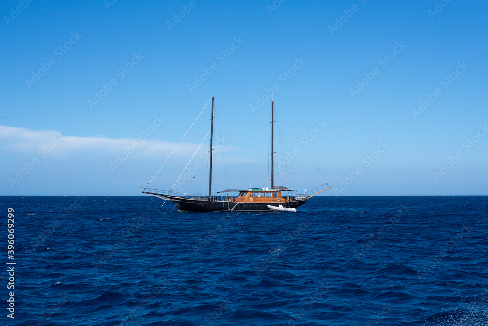 view of boat in the open sea, calm and blue in the Mediterranean between France and Italy for a peaceful, calm and zen vacation