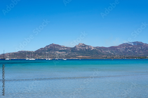 Calvi beach in summer view of the turquoise blue sea with the motagne in the background © JeanBrummel