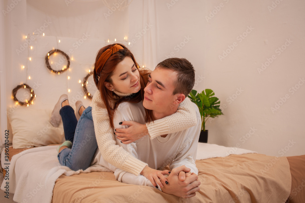 A young couple in love in a photo studio. Christmas scenery, guy and girl love each other. Posing for models in the studio on New Year's Eve Teenagers A young couple in love in a photo studio. Christmas scenery, guy and girl love each other. Posing for models in the studio on New Year's Eve Teenagers