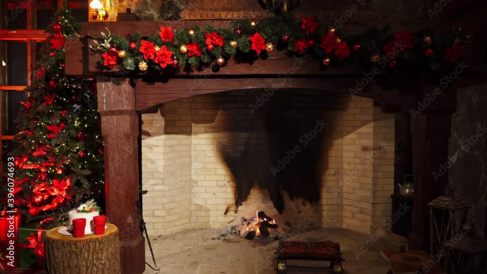 Festive cozy fireplace. New Year's design background near the fireplace. Christmas decorations inside the room with pleasant mantel. Warm home mood. Festive cozy fireplace. New Year's design background near the fireplace. Christmas decorations inside the room with pleasant mantel. Warm home mood.