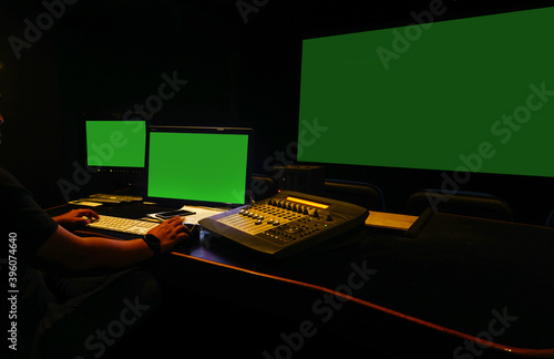 Sound engineer working in digital audio and video editing post production studio.Green screen.Selective focus.	
 photo