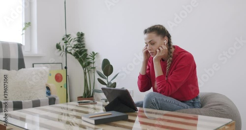 Girl sitting at home and talking on phone photo