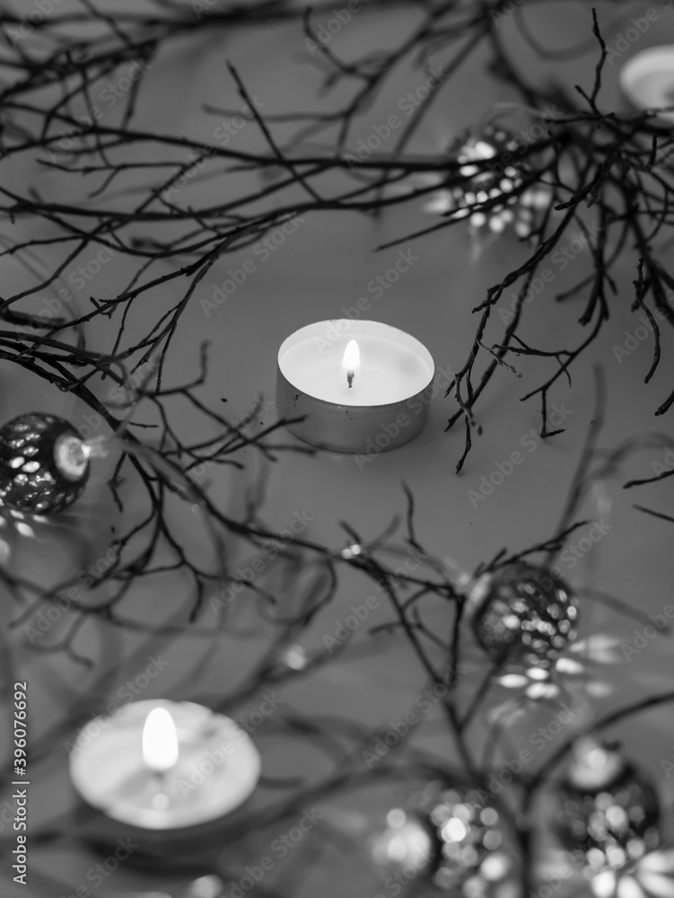 Green branches lie on a white background. And there are candles and lanterns nearby
Green branches lie on a white background. And there are candles and lanterns nearby