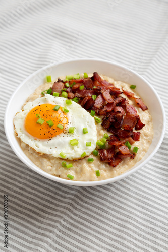 Homemade Cheesy Bacon Savory Oatmeal Bowl on cloth, side view.