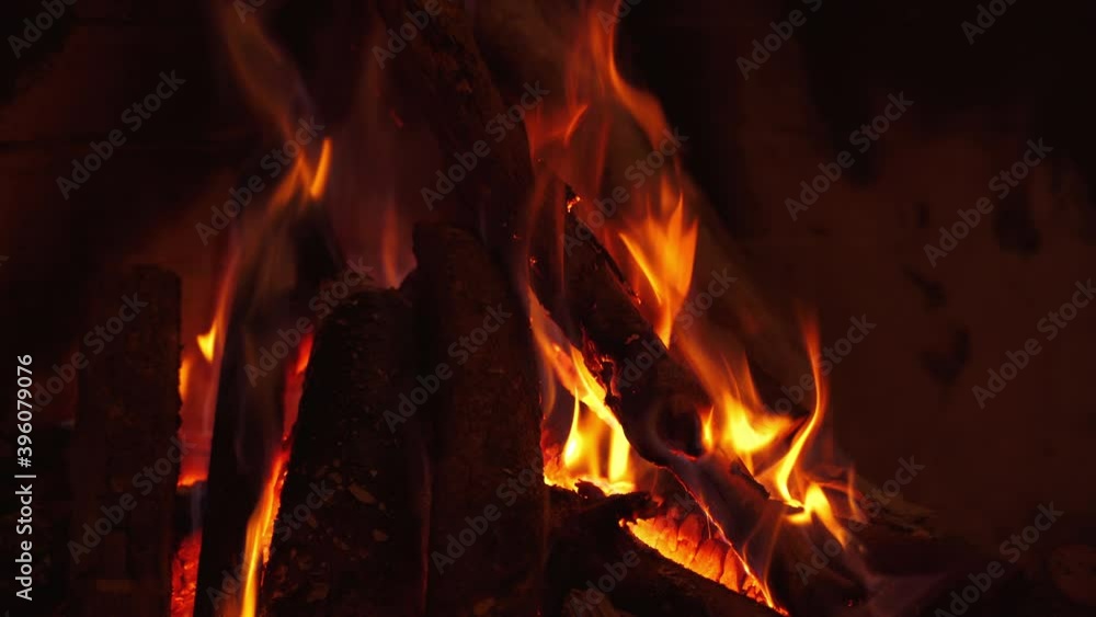 Burning wooden logs in fireplace. Fire in fireplace with logs and flames. Background of smoldering logs in flame. Cosy fireplace at home. Close-up. Burning wooden logs in fireplace. Fire in fireplace with logs and flames. Background of smoldering logs in flame. Cosy fireplace at home. Close-up.