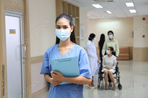 Portrait of nurse with patient wear face mask and sit on wheelchair meet and talking with doctor in hospital as background, healthcare treatment process and covid-19 pandemic concept