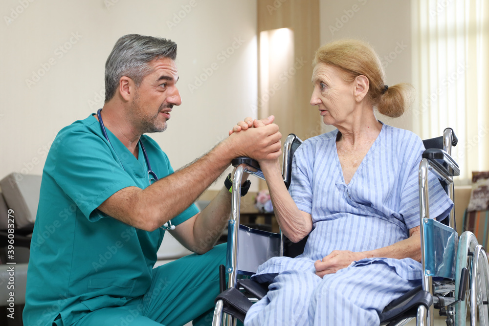 Doctor or assistance staff help or assist an elder patient woman while sitting on wheelchair in the hospital, healthcare or eldercare concept Doctor or assistance staff help or assist an elder patient woman while sitting on wheelchair in the hospital, healthcare or eldercare concept