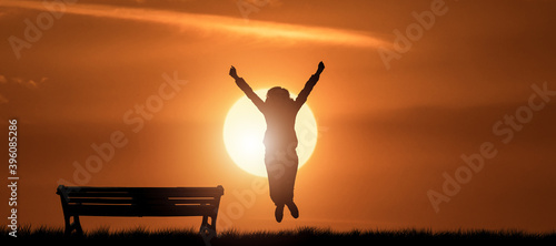 Happy girl jumping and enjoying life in outdoor nature at sunset evening.