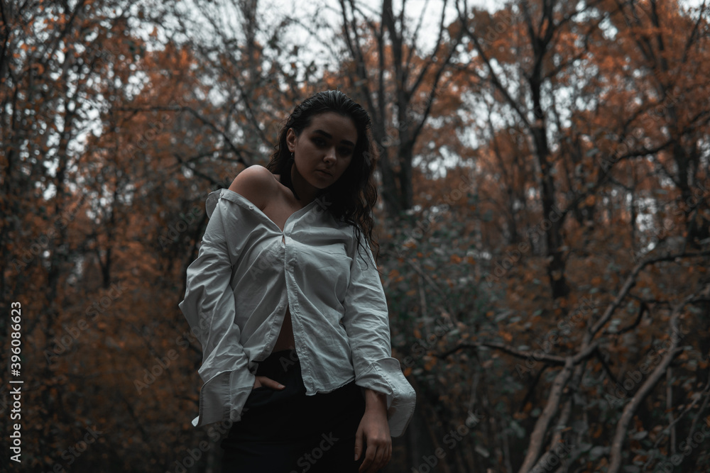 Girl in a white shirt in a dark forest Girl in a white shirt in a dark forest