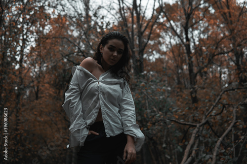 Girl in a white shirt in a dark forest