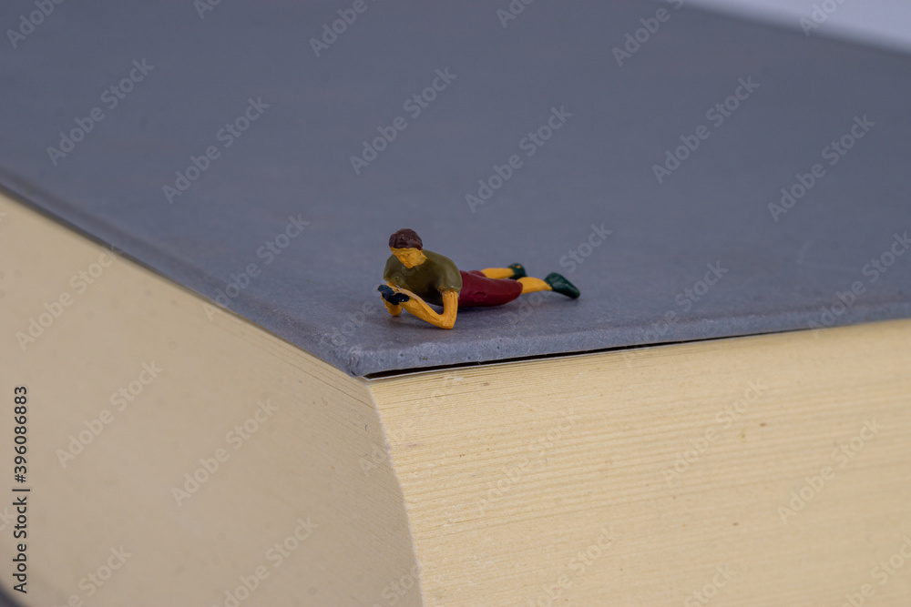 Obraz premium Small people reading on a book